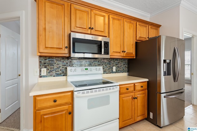 kitchen with light tile patterned floors, appliances with stainless steel finishes, ornamental molding, a textured ceiling, and decorative backsplash