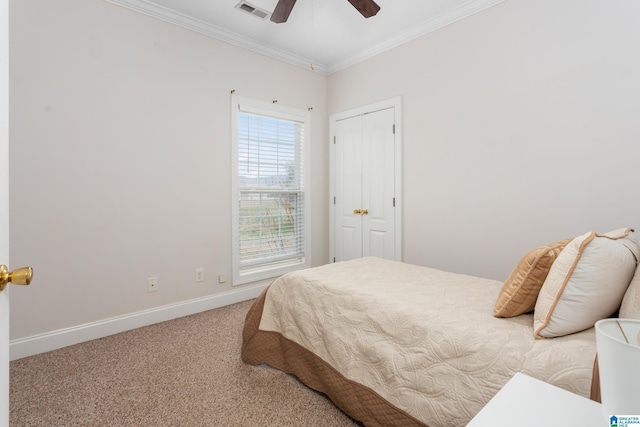 bedroom with crown molding, carpet floors, ceiling fan, and a closet