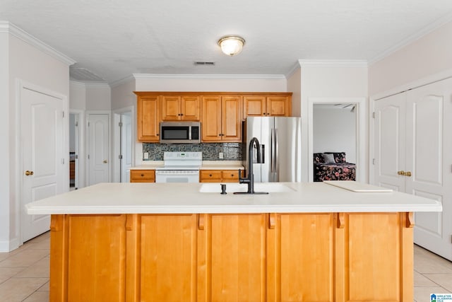 kitchen featuring sink, light tile patterned floors, appliances with stainless steel finishes, an island with sink, and backsplash