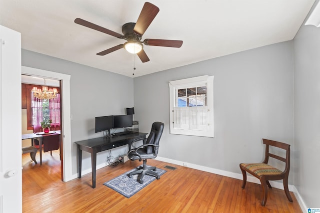 office area featuring ceiling fan with notable chandelier and hardwood / wood-style floors