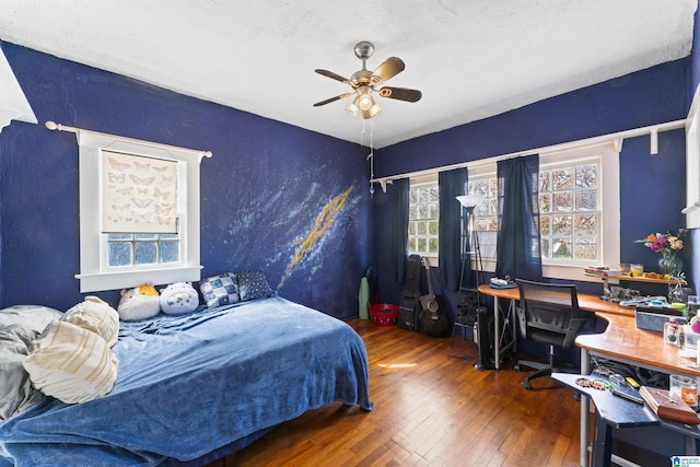 bedroom featuring ceiling fan, dark hardwood / wood-style floors, and a textured ceiling