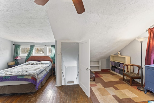 bedroom featuring lofted ceiling, a textured ceiling, dark wood-type flooring, and ceiling fan