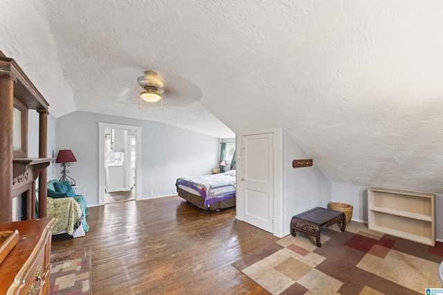 bedroom featuring ceiling fan, lofted ceiling, a textured ceiling, and dark hardwood / wood-style flooring