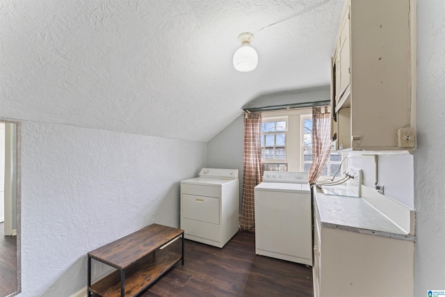 clothes washing area with washing machine and dryer, dark wood-type flooring, sink, and a textured ceiling