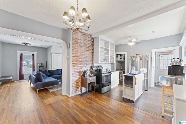 kitchen featuring appliances with stainless steel finishes, dark hardwood / wood-style floors, a textured ceiling, and decorative light fixtures