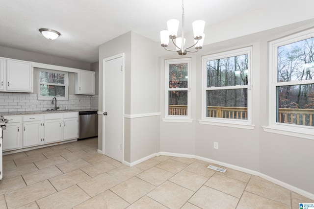 kitchen featuring sink, dishwasher, white cabinetry, hanging light fixtures, and backsplash