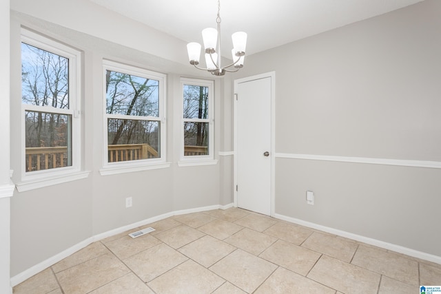 unfurnished dining area with light tile patterned flooring and an inviting chandelier