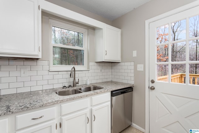 kitchen with sink, light stone countertops, white cabinets, and dishwasher