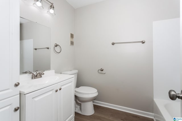 bathroom with vanity, toilet, a bathing tub, and hardwood / wood-style floors