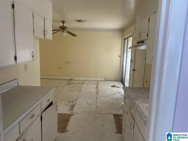 kitchen featuring ceiling fan and white cabinets