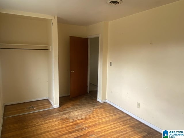 unfurnished bedroom with hardwood / wood-style floors and a closet