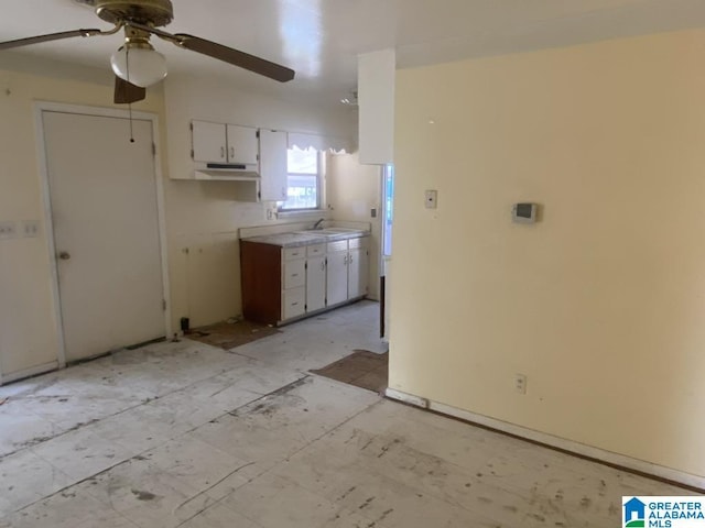 kitchen featuring white cabinetry, ceiling fan, and sink