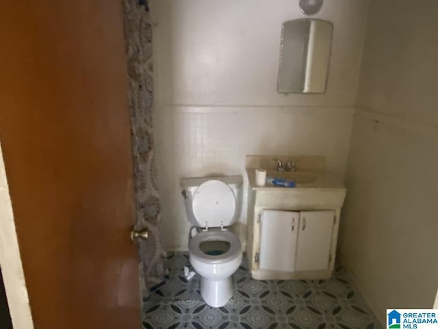 bathroom featuring vanity, toilet, and tile patterned flooring