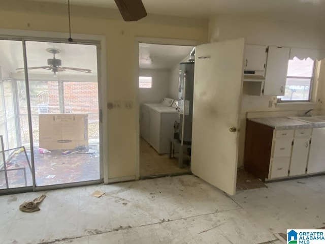 kitchen featuring pendant lighting, a wealth of natural light, white cabinets, and washer and clothes dryer