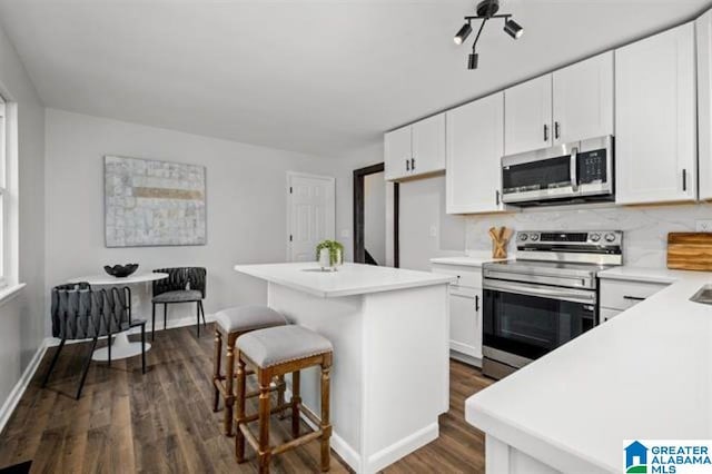 kitchen with appliances with stainless steel finishes, a center island, and white cabinets