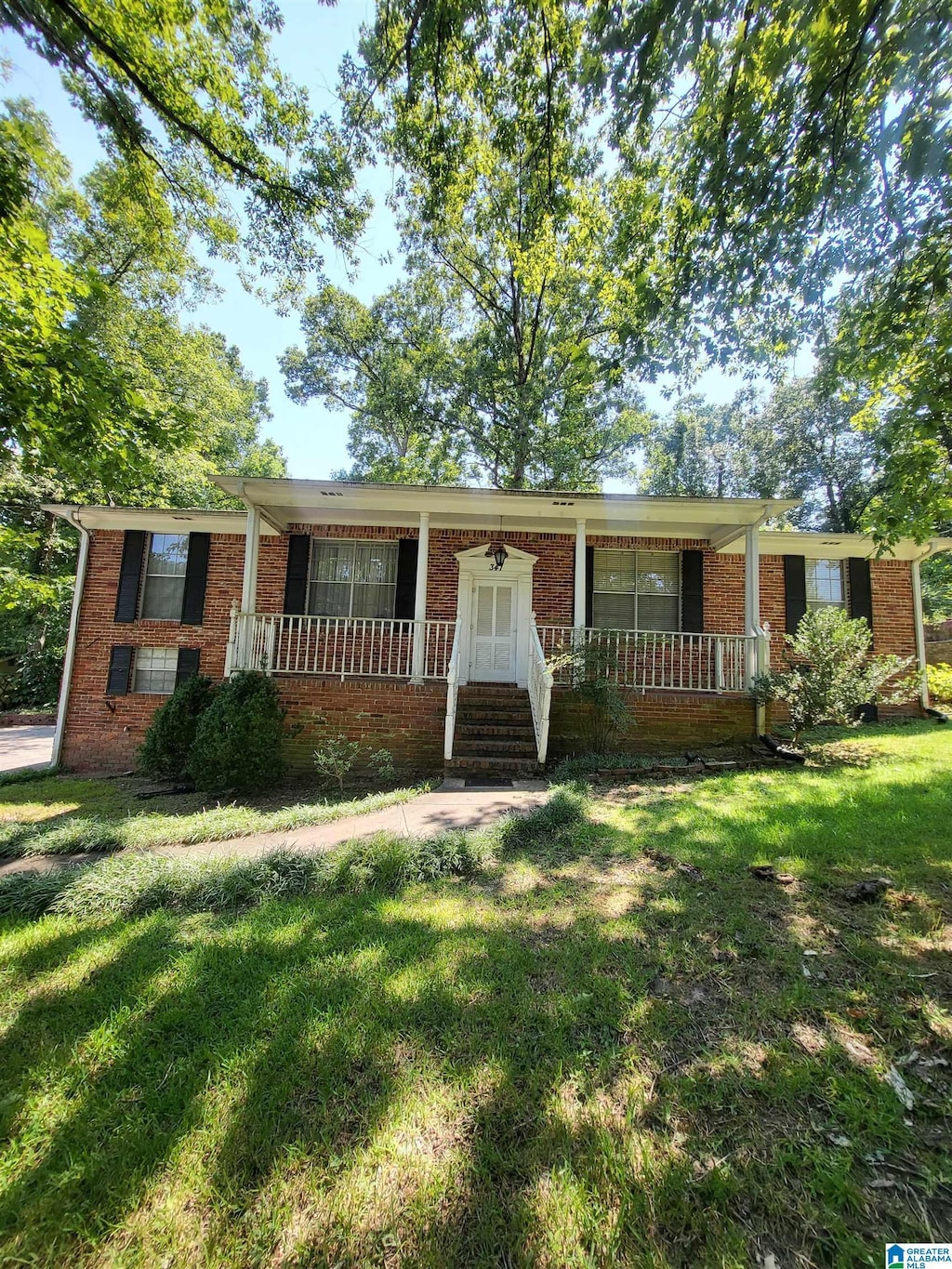 ranch-style home with a porch and a front lawn