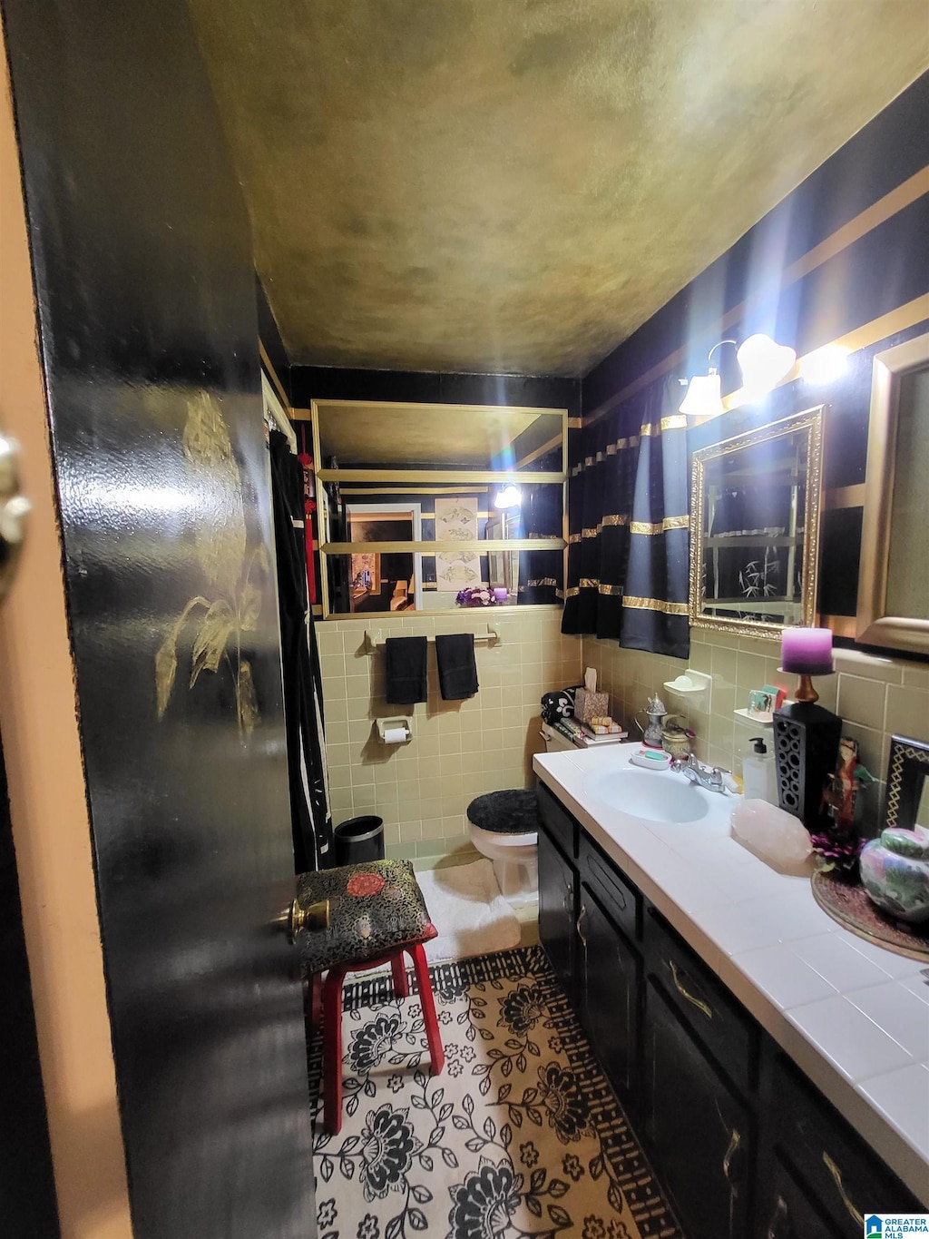 bathroom with tile patterned floors, toilet, tile walls, and vanity