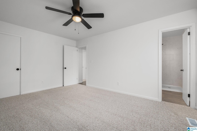 unfurnished bedroom with ceiling fan, light colored carpet, and ensuite bath