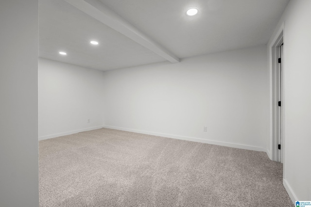 carpeted spare room featuring beam ceiling