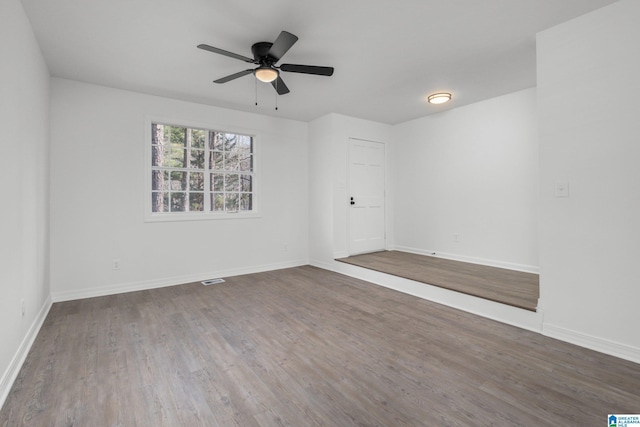 unfurnished room with dark hardwood / wood-style flooring and ceiling fan