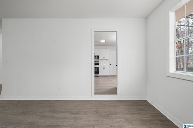 spare room featuring dark wood-type flooring