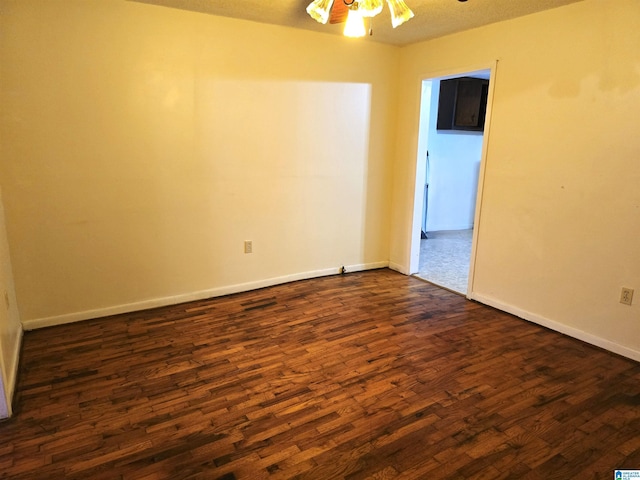 spare room featuring dark hardwood / wood-style floors and ceiling fan