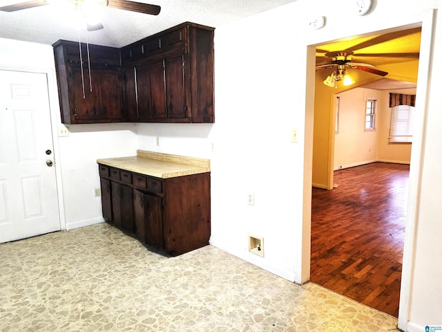 kitchen featuring a textured ceiling, dark brown cabinets, and ceiling fan