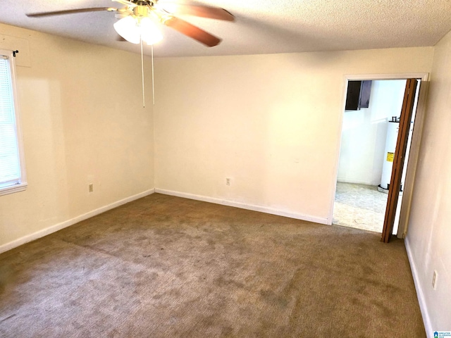 empty room featuring water heater, ceiling fan, carpet flooring, and a textured ceiling