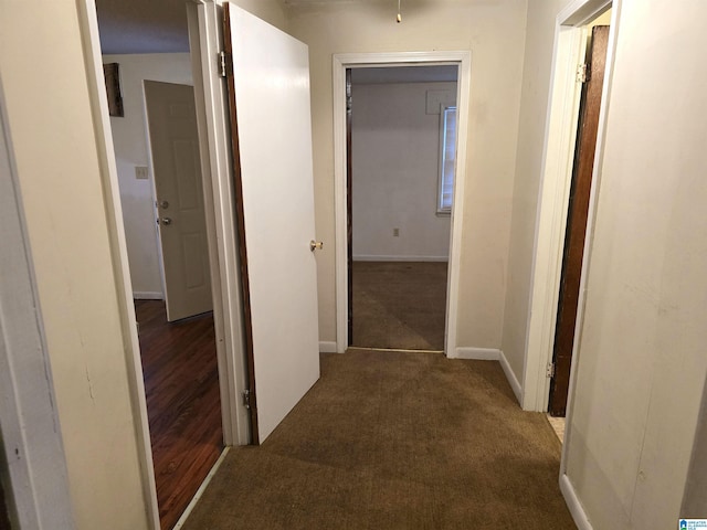 hallway featuring dark carpet