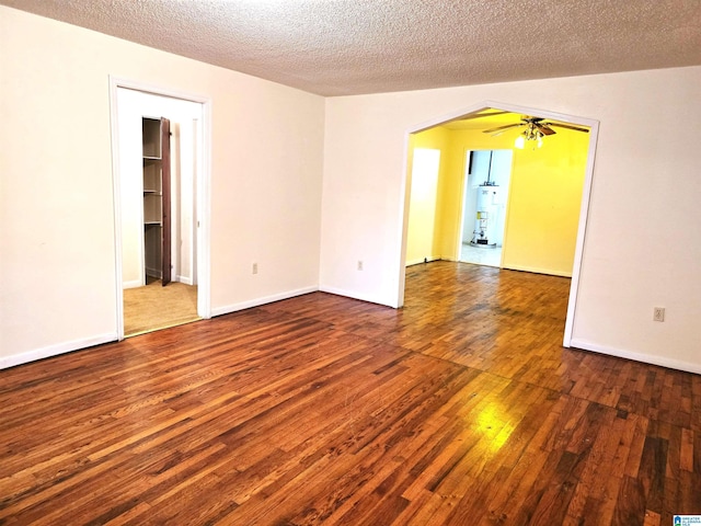 empty room featuring hardwood / wood-style flooring, water heater, and a textured ceiling