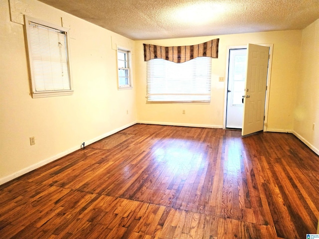 empty room featuring dark hardwood / wood-style flooring and a textured ceiling