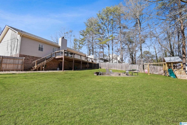 view of yard featuring a fire pit, a playground, and a deck