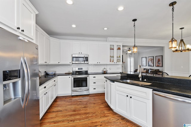 kitchen with stainless steel appliances, sink, pendant lighting, and white cabinets