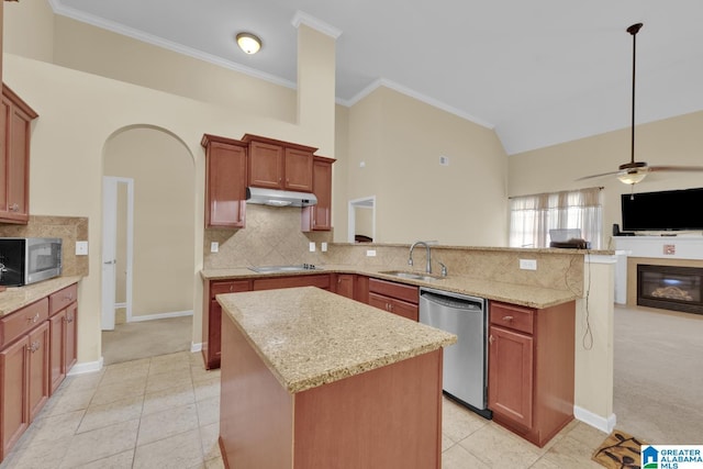 kitchen featuring light stone counters, appliances with stainless steel finishes, sink, and a kitchen island