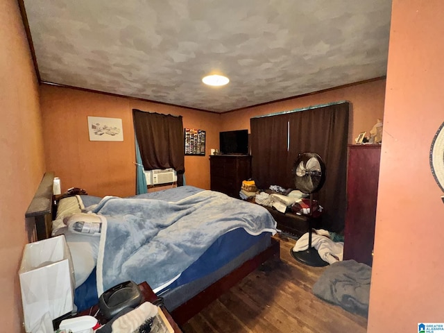 bedroom featuring ornamental molding and wood finished floors