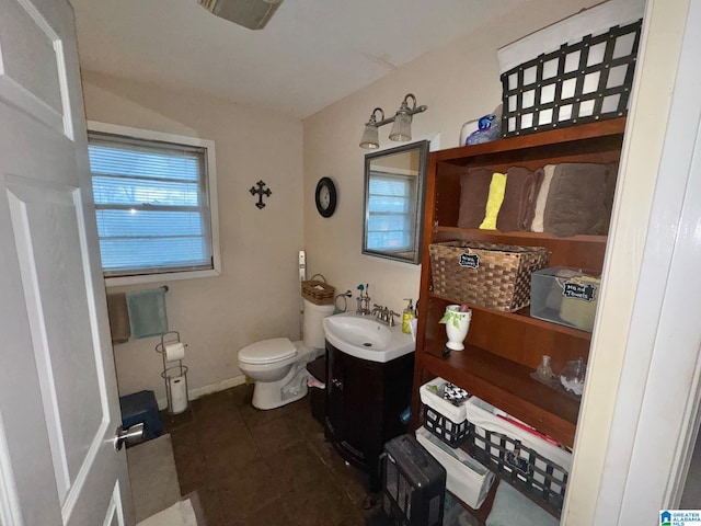 bathroom with baseboards, vanity, toilet, and tile patterned floors