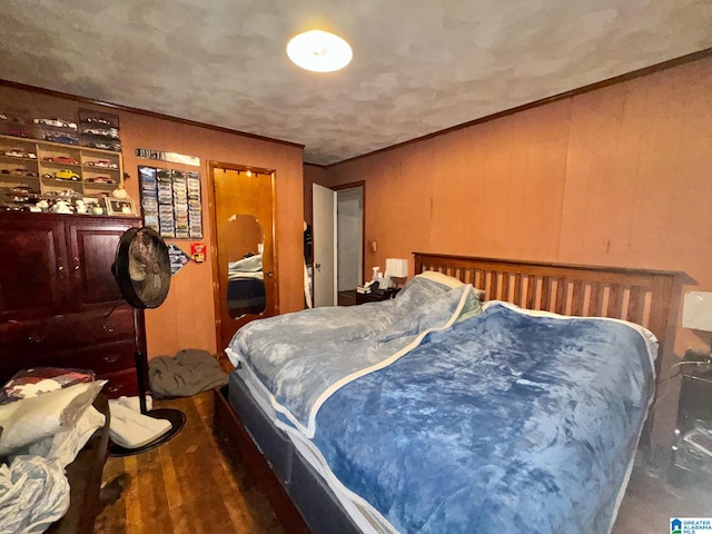 bedroom with crown molding and wood finished floors