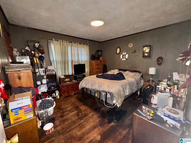 bedroom featuring wood finished floors and crown molding