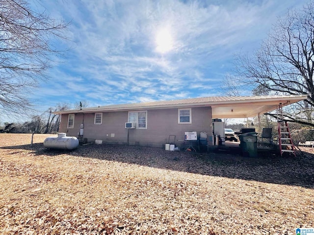 back of house with cooling unit and a carport