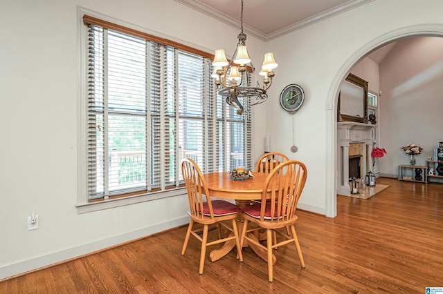 dining room featuring hardwood / wood-style flooring, ornamental molding, and a notable chandelier