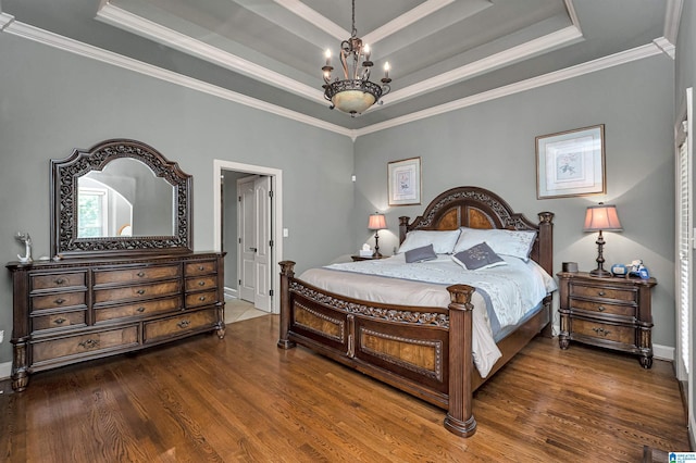 bedroom featuring dark hardwood / wood-style flooring, crown molding, a raised ceiling, and an inviting chandelier