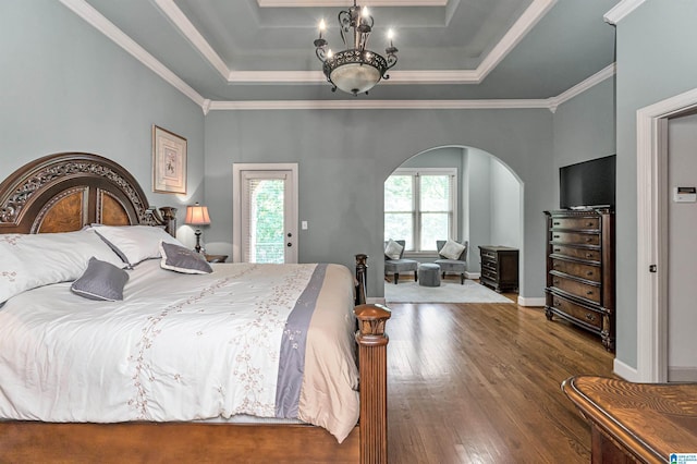 bedroom with crown molding, dark hardwood / wood-style flooring, a raised ceiling, and an inviting chandelier