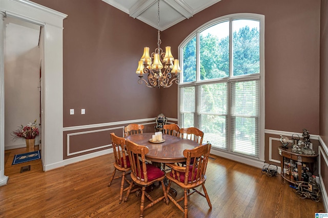 dining space featuring coffered ceiling, an inviting chandelier, ornamental molding, beam ceiling, and hardwood / wood-style floors