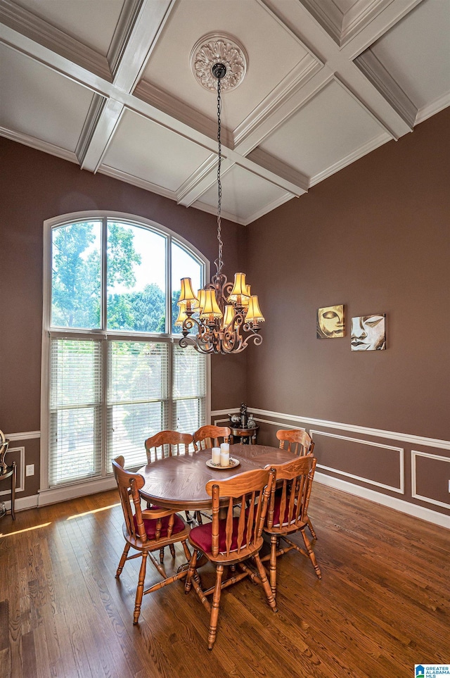 dining area with beamed ceiling, wood-type flooring, coffered ceiling, and an inviting chandelier