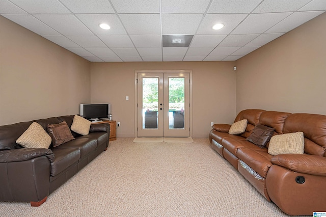 living room featuring light colored carpet, a drop ceiling, and french doors