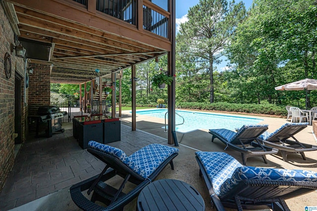 view of swimming pool with grilling area and a patio