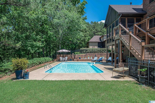 view of pool featuring a sunroom, a patio area, and a lawn