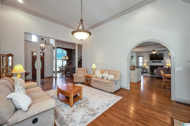 living room featuring dark hardwood / wood-style flooring, crown molding, and ceiling fan