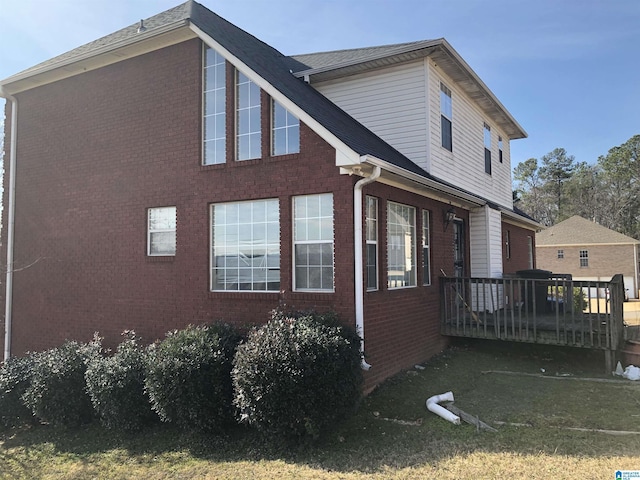 view of home's exterior featuring a wooden deck and a yard