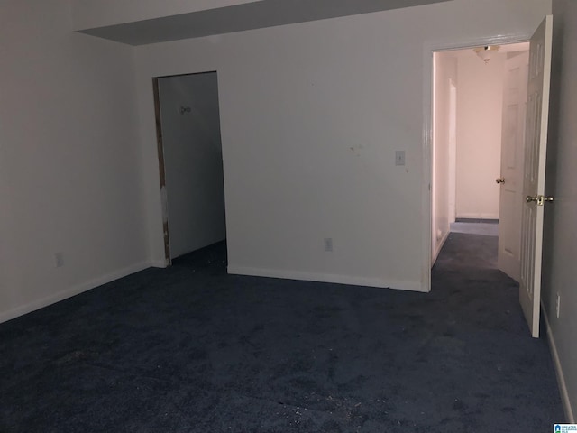 empty room with dark colored carpet